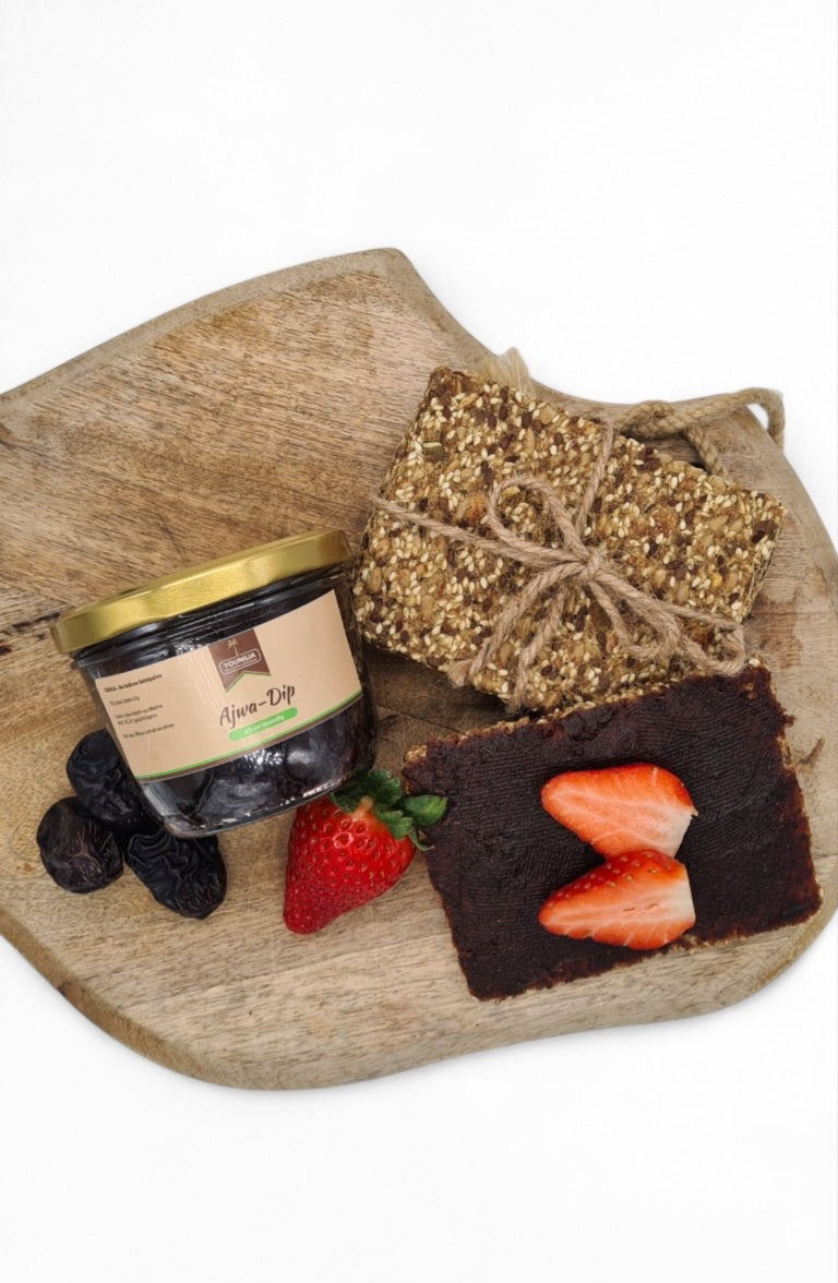 Ajwa-Dip von YOUNILIA mit Datteln, Knäckebrot und frischen Erdbeeren auf Holzbrett – gesund und lecker