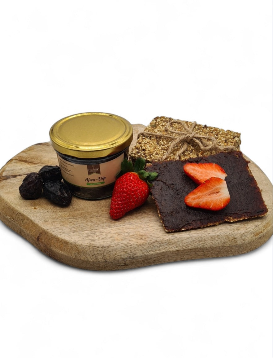 Ajwa-Dip von YOUNILIA mit Datteln, Knäckebrot und Erdbeeren auf Holzbrett – gesund & lecker