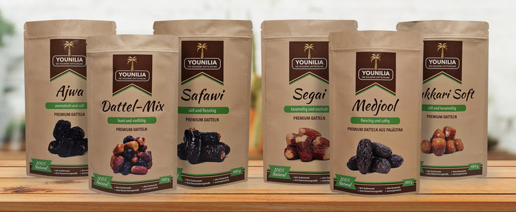 Verschiedene Premium-Dattelprodukte von Younilia: Ajwa, Dattel-Mix, Safawi, Segai, Medjool und Sukari Soft in 450g Verpackungen, ideal für gesunde Snacks.
