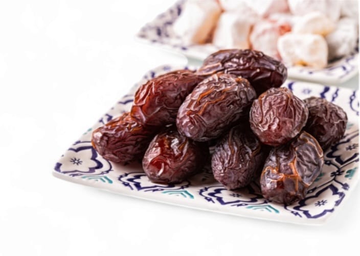 Medjool Datteln auf einem dekorativen Teller mit anderen Süßigkeiten, ideal für das Ramadan-Buffet oder festliche Anlässe.
